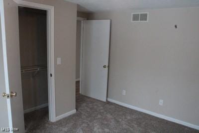 unfurnished bedroom with carpet, a closet, visible vents, and baseboards