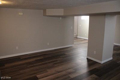 finished basement with baseboards and dark wood finished floors