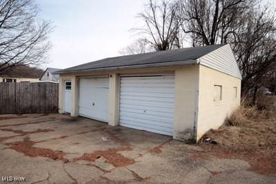 detached garage featuring fence