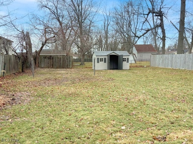 view of yard with an outbuilding, a fenced backyard, and a storage unit