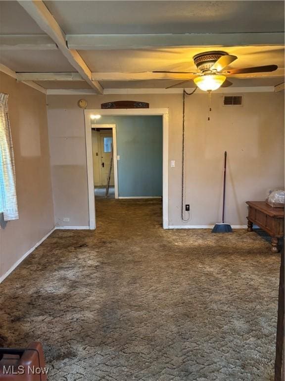 carpeted spare room featuring a ceiling fan, beamed ceiling, and baseboards