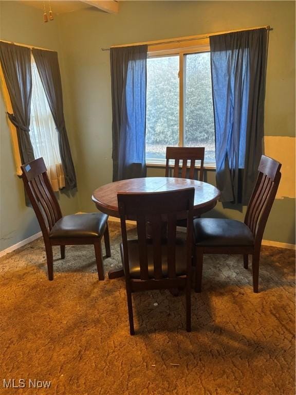 carpeted dining room with baseboards