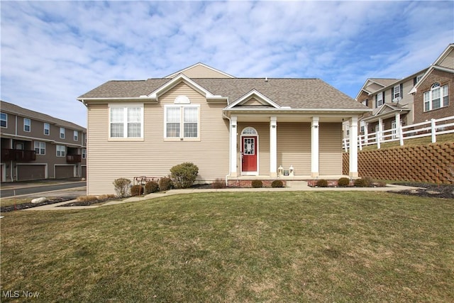 view of front facade featuring a porch, a front yard, fence, and a shingled roof