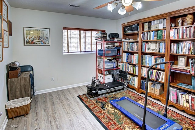 workout room featuring a ceiling fan, baseboards, visible vents, and wood finished floors