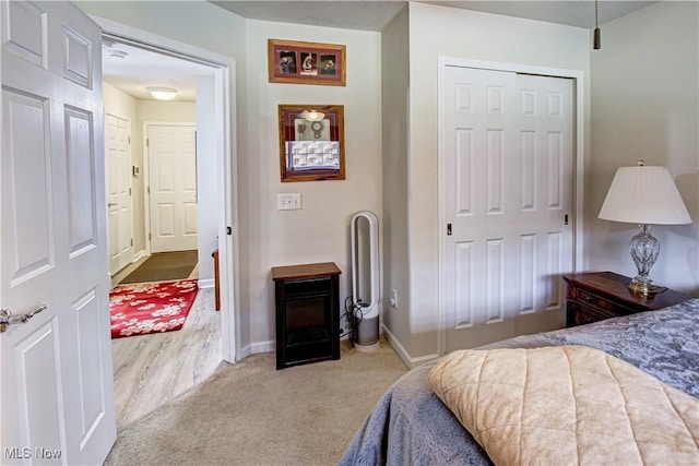 bedroom with a closet, carpet flooring, and baseboards