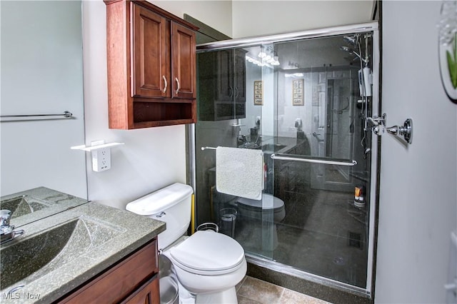 full bathroom featuring a stall shower, vanity, and toilet