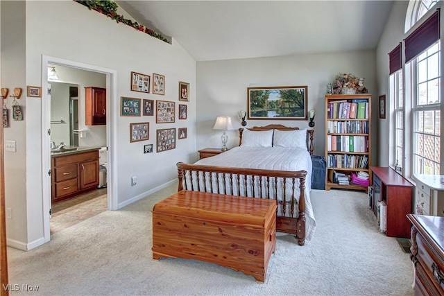 bedroom with lofted ceiling, light colored carpet, a sink, and baseboards