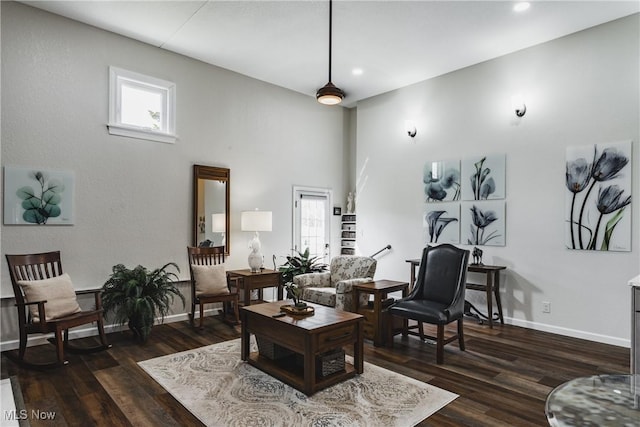 living area featuring dark wood-style floors, recessed lighting, a towering ceiling, and baseboards