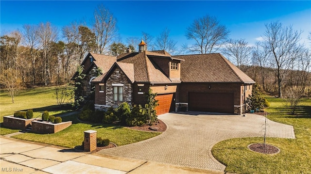 view of front of property with stone siding, a front yard, and decorative driveway