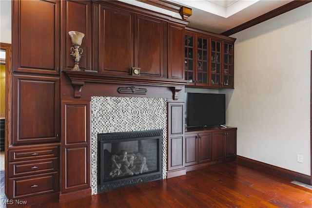 unfurnished living room with visible vents, a fireplace, baseboards, and dark wood-type flooring