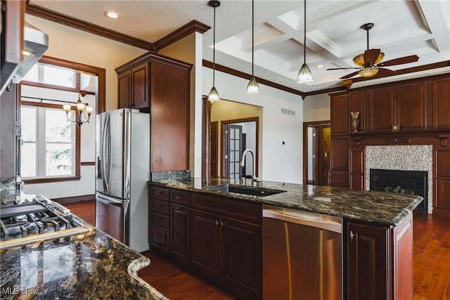 kitchen with coffered ceiling, ornamental molding, stainless steel appliances, and a sink