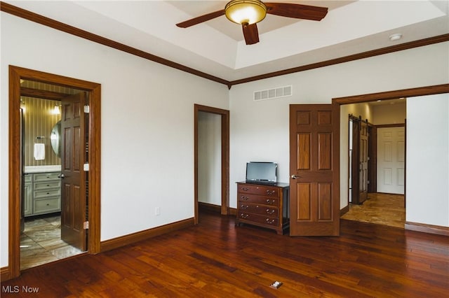 unfurnished bedroom with visible vents, crown molding, baseboards, and wood finished floors