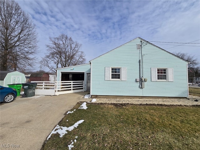 view of home's exterior with fence and driveway