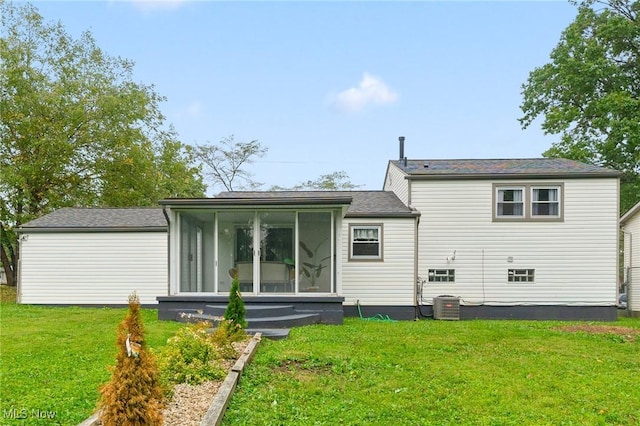 back of property with a sunroom, central AC, and a lawn