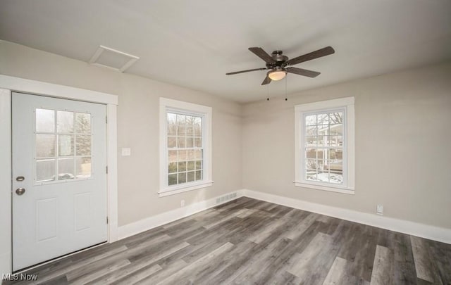 foyer with a ceiling fan, wood finished floors, visible vents, and baseboards