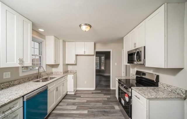 kitchen with stainless steel appliances, white cabinetry, and a sink