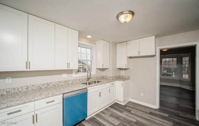 kitchen with baseboards, a sink, dishwasher, and white cabinetry