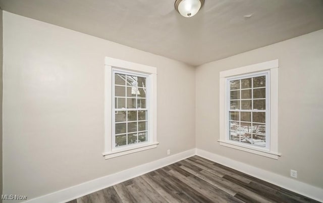 empty room featuring dark wood-type flooring and baseboards