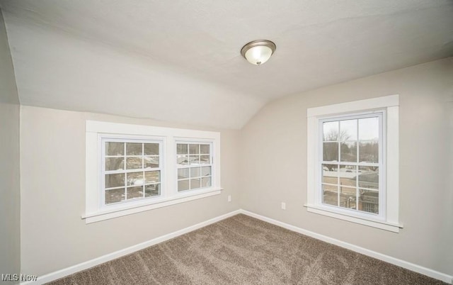 additional living space with carpet flooring, vaulted ceiling, and baseboards