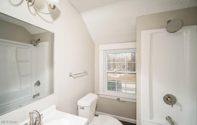 bathroom featuring a textured ceiling, a sink, bathing tub / shower combination, and lofted ceiling