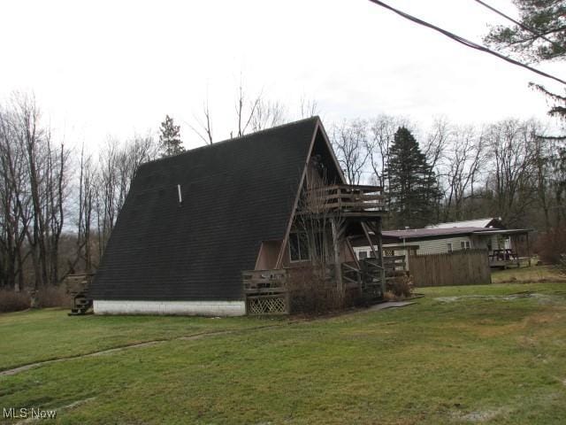 view of property exterior featuring a yard and a wooden deck