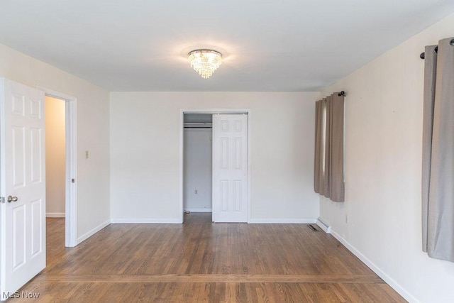 unfurnished bedroom with a closet, baseboards, and wood finished floors