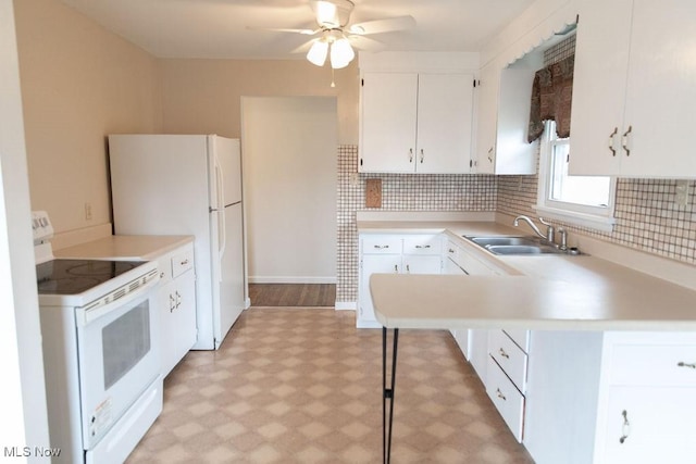 kitchen featuring white appliances, white cabinets, light countertops, light floors, and a sink