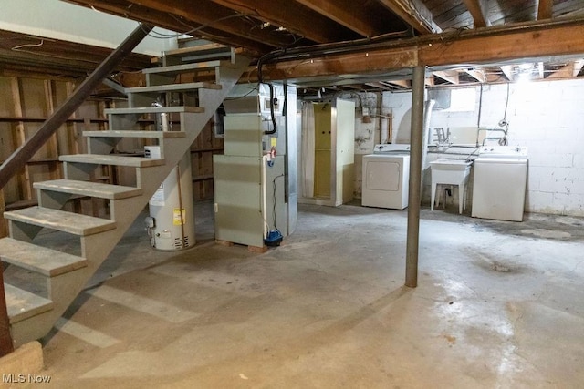 unfinished below grade area with a sink, water heater, stairway, independent washer and dryer, and heating unit