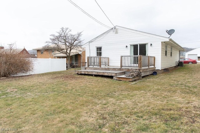 rear view of house with cooling unit, a yard, a wooden deck, and fence