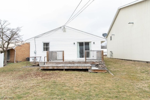 back of house with a deck and a lawn