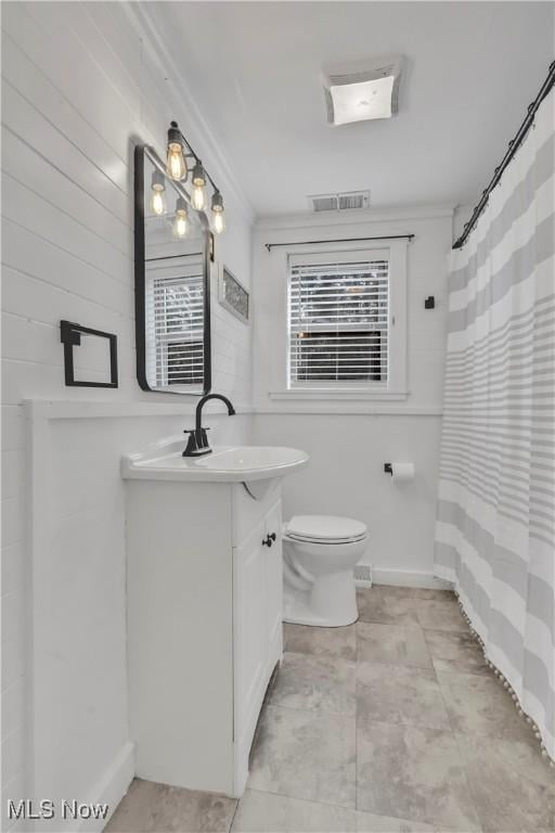 full bathroom with baseboards, visible vents, toilet, crown molding, and vanity