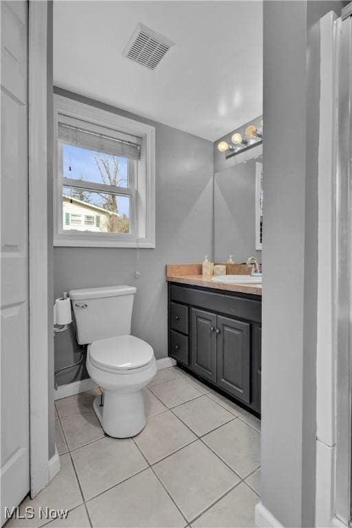 bathroom featuring tile patterned flooring, visible vents, vanity, and toilet