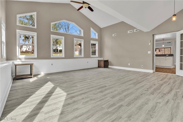 unfurnished living room with ceiling fan, high vaulted ceiling, and wood finished floors