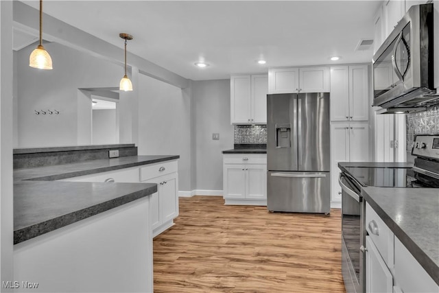 kitchen with dark countertops, light wood-type flooring, and stainless steel appliances