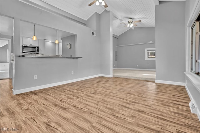 unfurnished living room featuring ceiling fan, light wood finished floors, visible vents, and baseboards