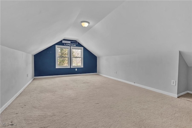 bonus room featuring lofted ceiling, carpet, and baseboards