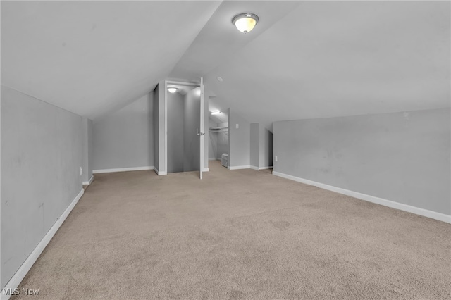 bonus room with lofted ceiling, baseboards, and light colored carpet