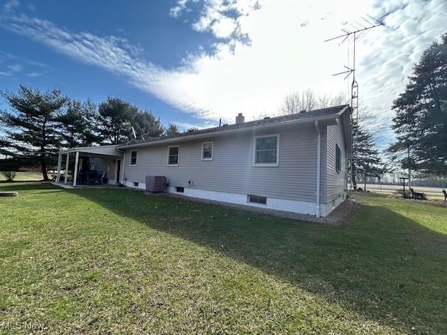 rear view of property with central AC and a yard