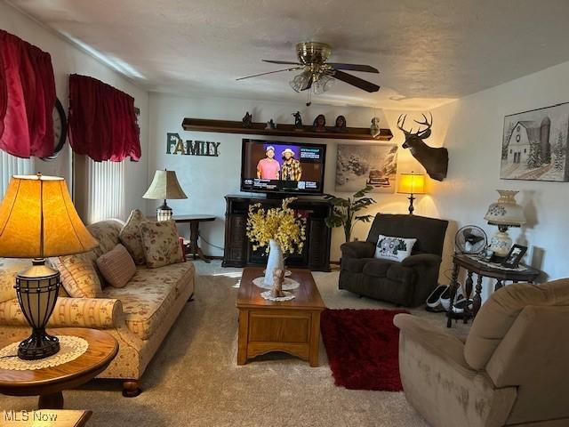 living area featuring carpet floors and ceiling fan