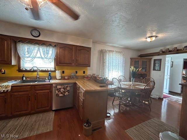 kitchen with a sink, a healthy amount of sunlight, a peninsula, and dishwasher