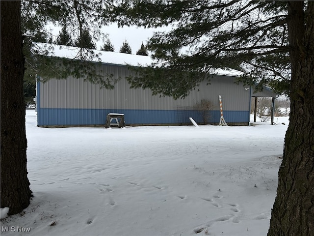 view of snowy exterior featuring an outbuilding and an outdoor structure