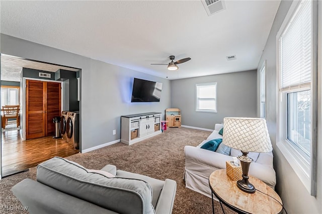 living area featuring carpet, visible vents, ceiling fan, and baseboards