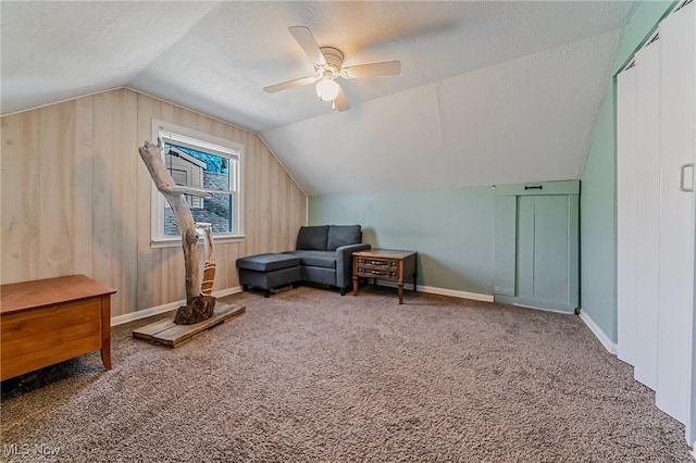 living area featuring a textured ceiling, ceiling fan, carpet flooring, and lofted ceiling