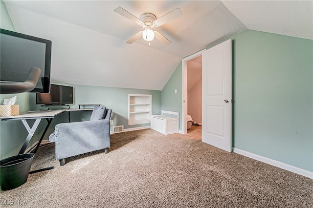 office space featuring baseboards, visible vents, vaulted ceiling, carpet flooring, and built in shelves