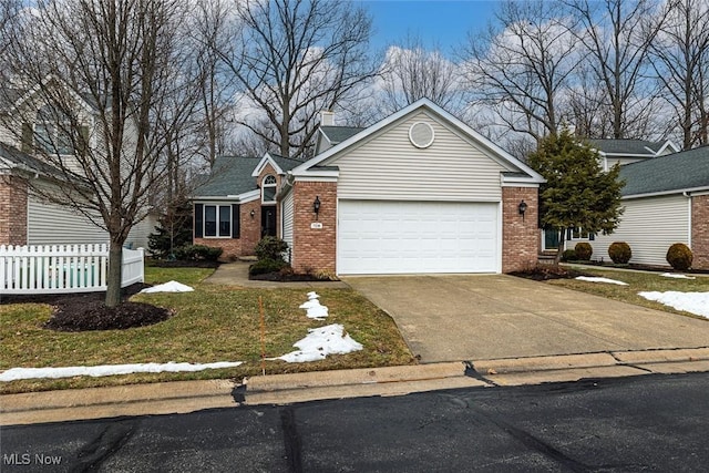 view of front facade featuring driveway, an attached garage, fence, and brick siding