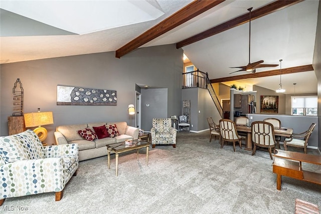 living room with a ceiling fan, baseboards, stairway, beamed ceiling, and carpet