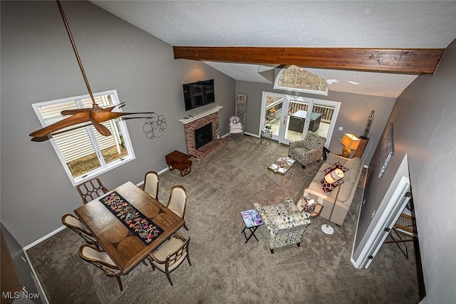 unfurnished living room with carpet flooring, a fireplace, lofted ceiling with beams, and a textured ceiling