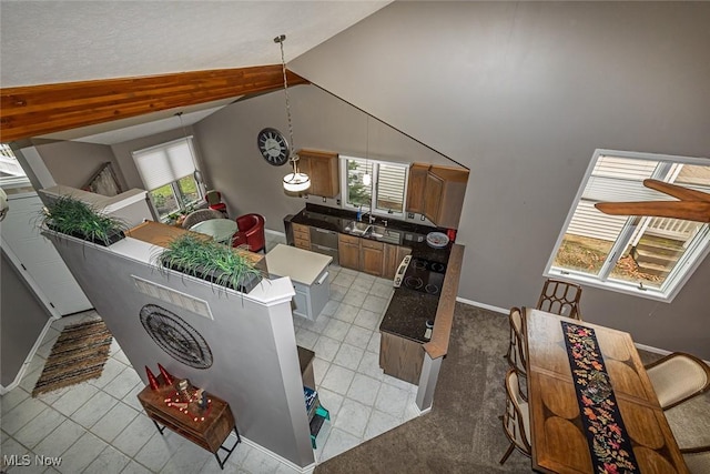 kitchen featuring light tile patterned floors, dishwashing machine, dark countertops, and high vaulted ceiling