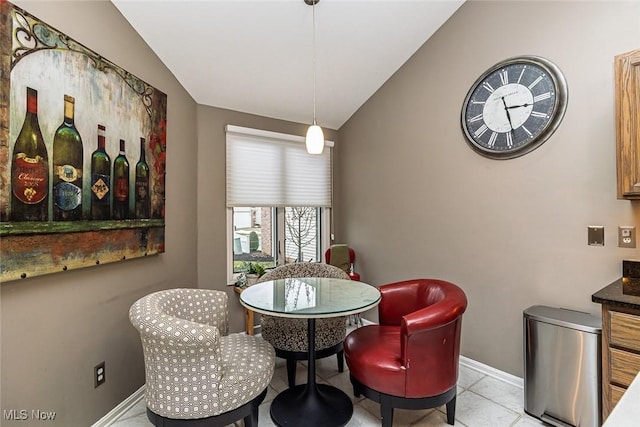 dining area featuring lofted ceiling and baseboards