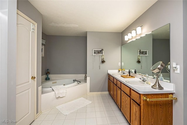 bathroom featuring double vanity, a tub with jets, a sink, and tile patterned floors